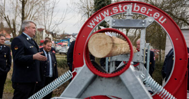 Kreisbrandmeister Raimund Großberger erklärt den Kommandanten den neuen Holzspannungssimulator vor der Frankenlandhalle in Schnelldorf.